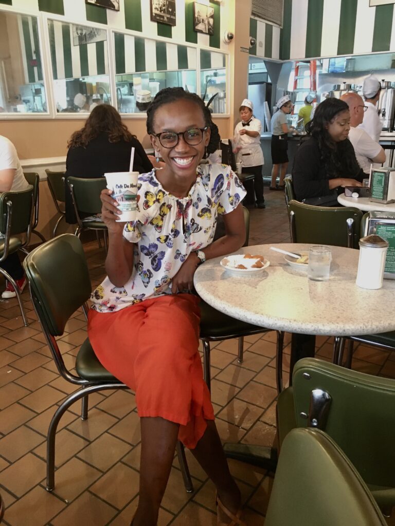 afoma at cafe du monde holding a coffee