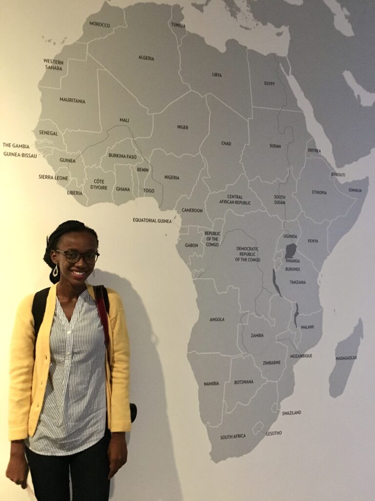 black girl standing in front of africa map