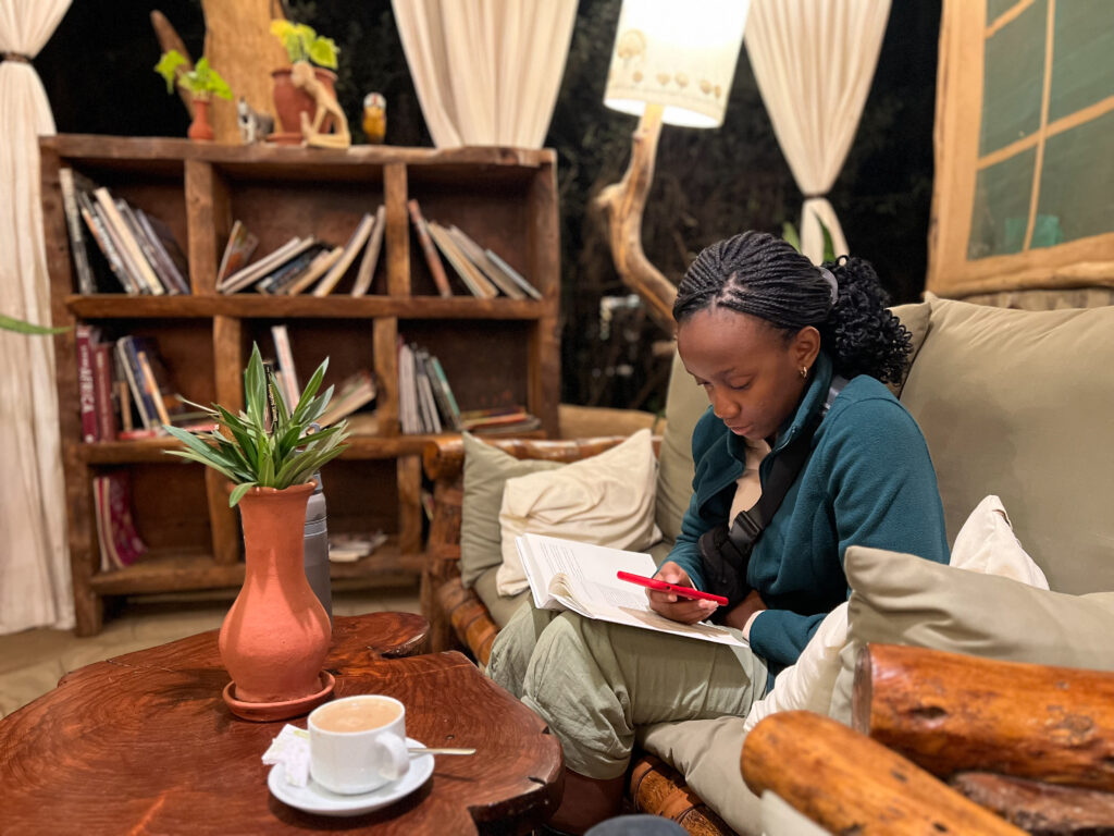 black woman sits in kibo safari camp lounge