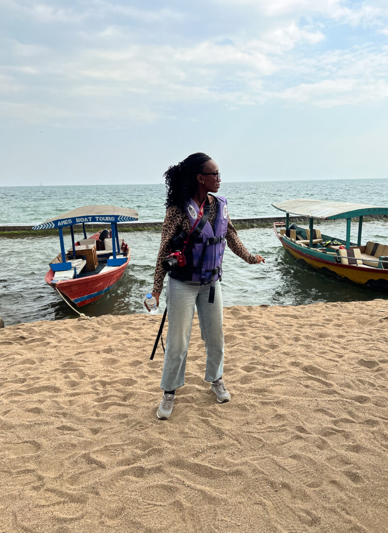 black woman stands in front of boats at lake kivu