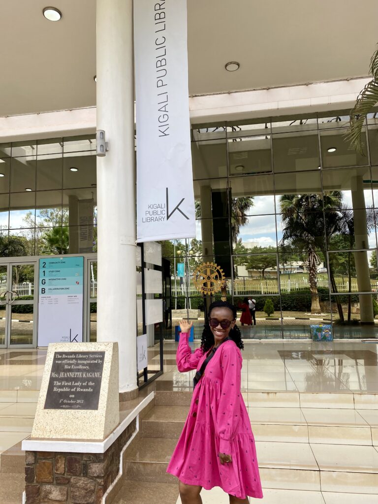 a black woman stands in front of kigali public library