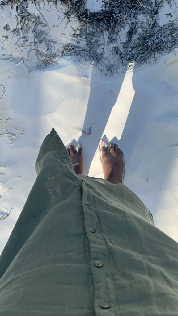 a woman's feet on white sand beaches