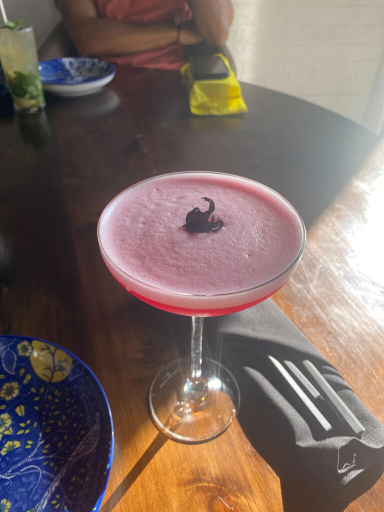 a wine glass full of a pink cocktail - at bang bang thai nairobi