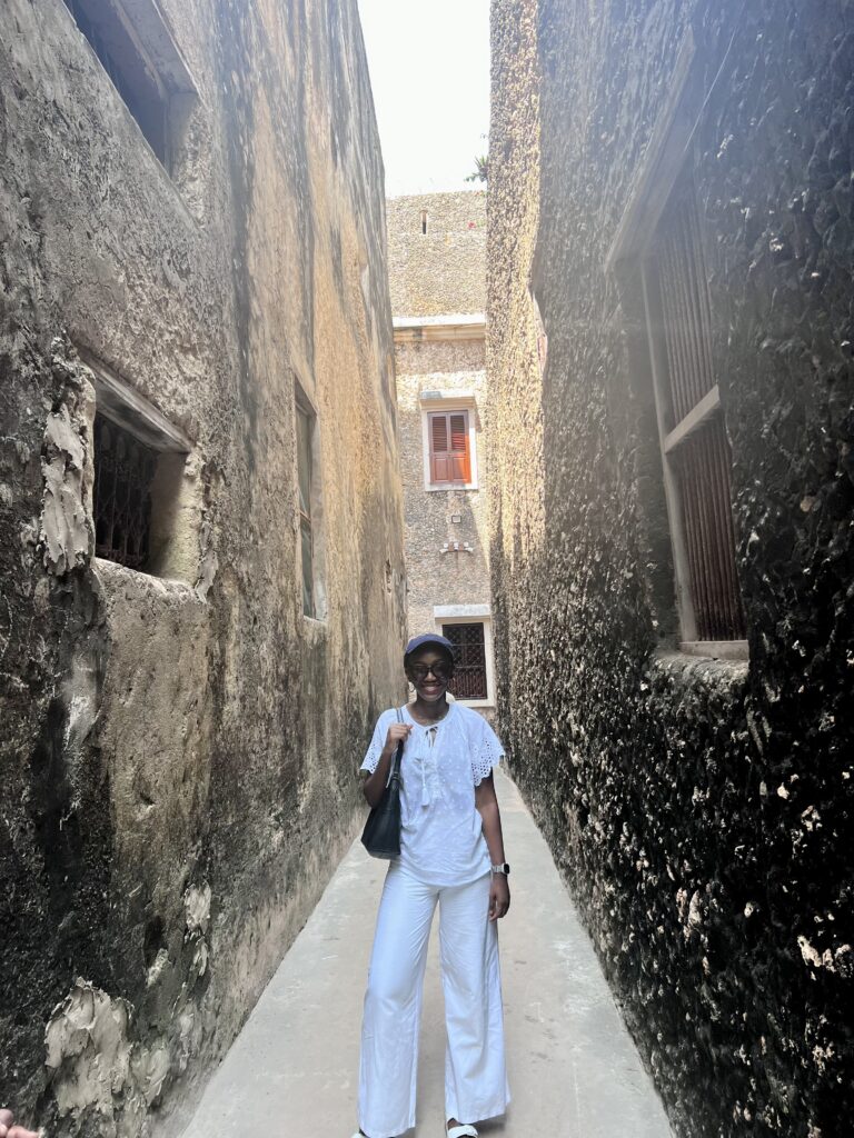 a black woman standing between walls in lamu town